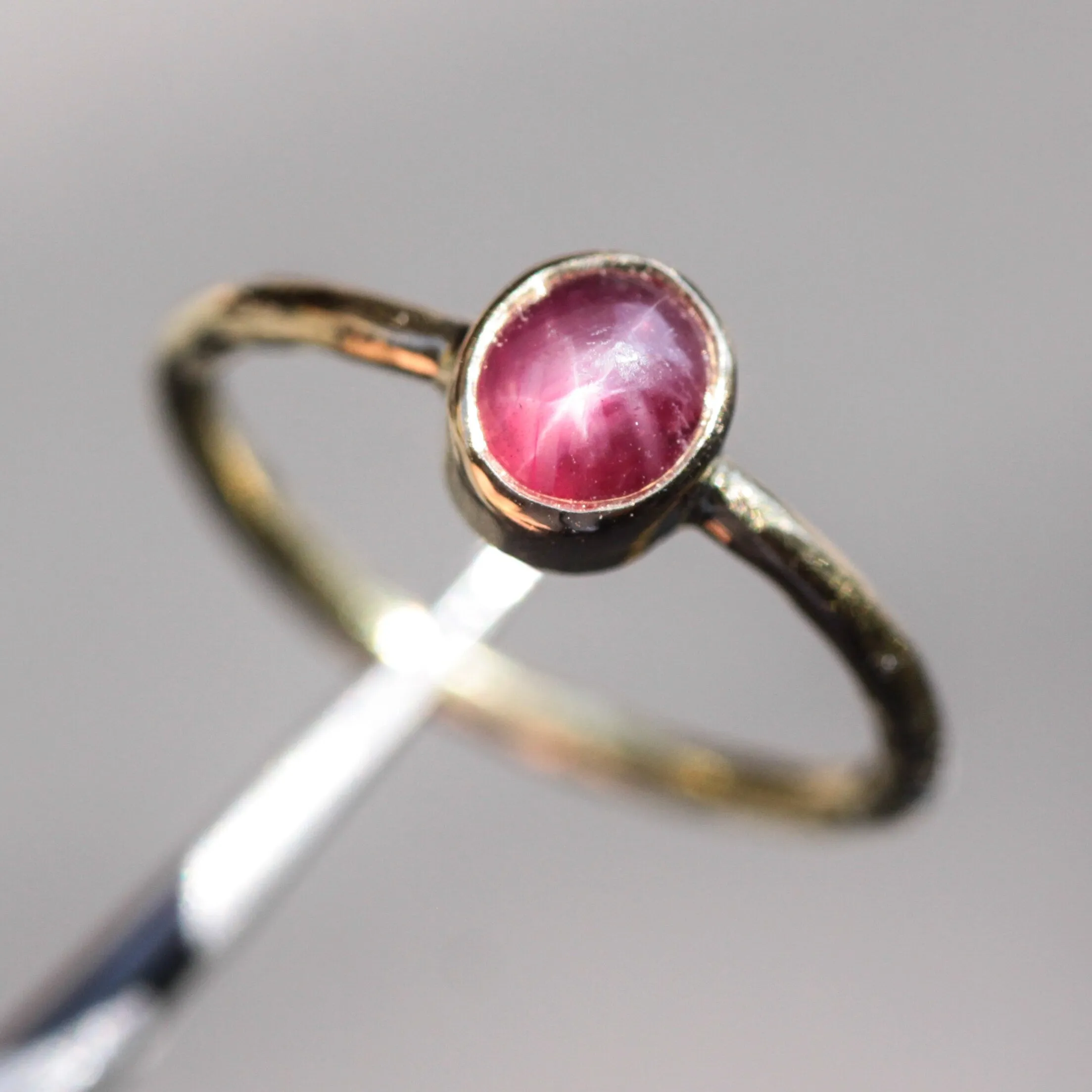 Oval star ruby ring in bezel settings with 18k gold texture band